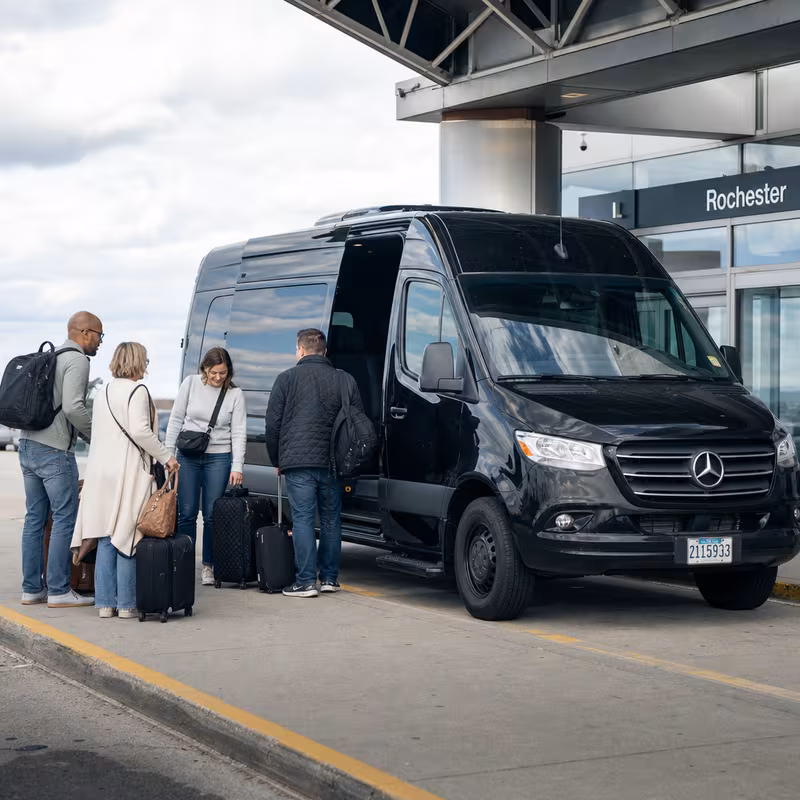 Group boarding a white charter bus for Airport Transportation transportation in Rochester