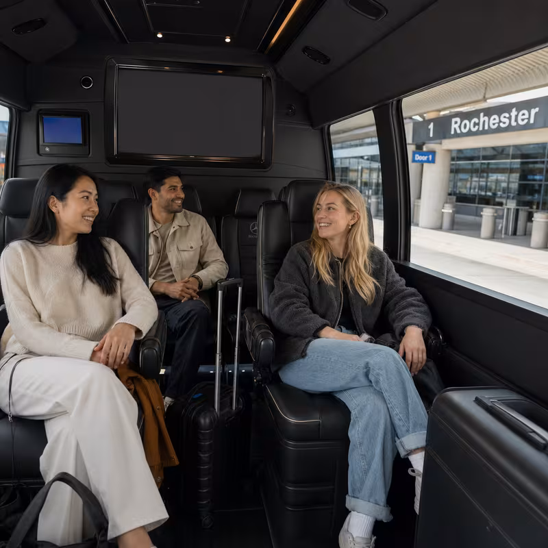 Passengers loading luggage while boarding an Rochester group shuttle