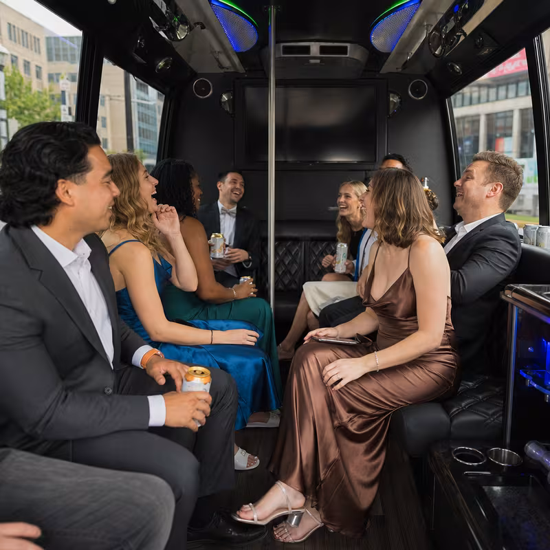 Party bus interior with wraparound leather seating and LED lighting in Rochester