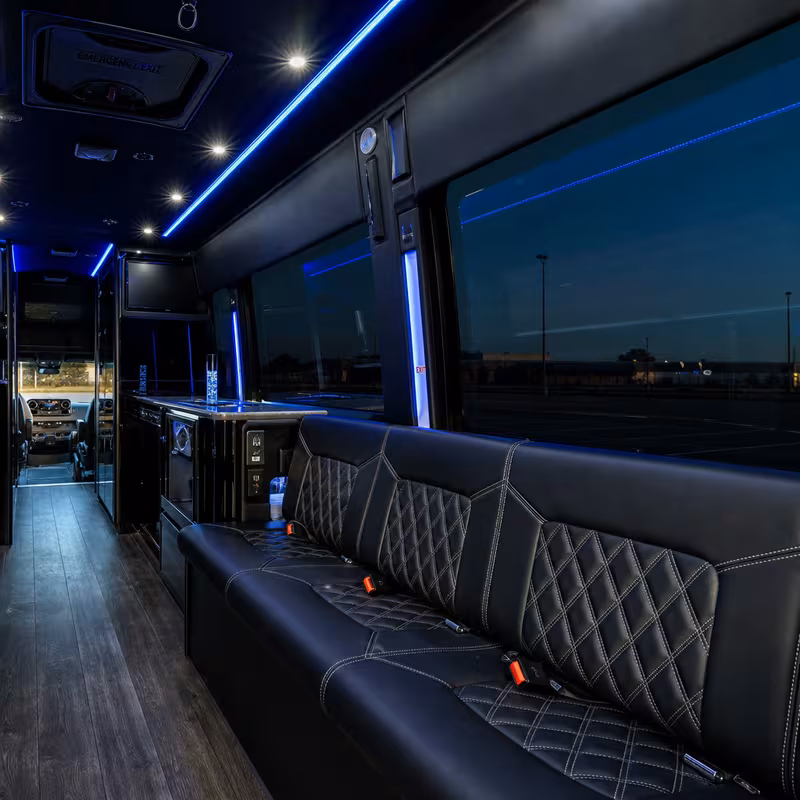 Party bus interior with wraparound leather seating and LED lighting in Rochester