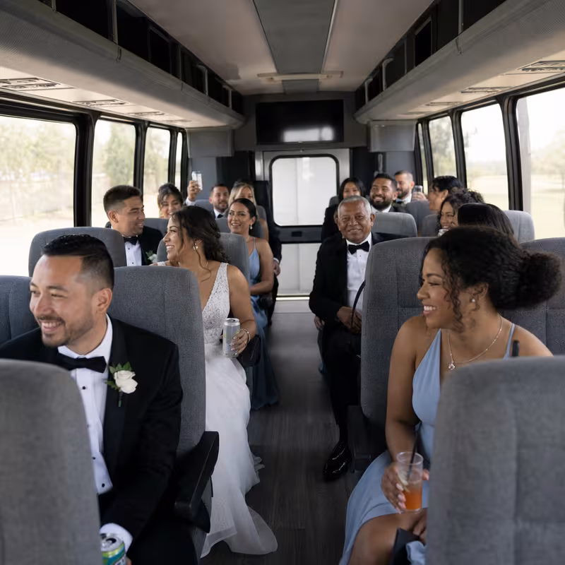 Group boarding a white charter bus for Wedding Transportation transportation in Rochester